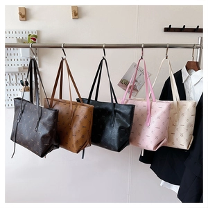 Detailed view of large monogram tote bags in multiple colors with bear pattern