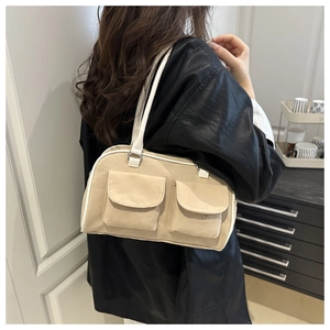 Detail of light beige multi-pocket shoulder bag with white straps in a lifestyle setting