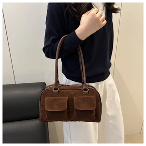 Close-up of brown suede hobo bag with dual front pockets and long leather handles