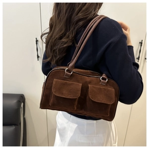 Detailed shot of dark brown suede shoulder bag featuring retro front flap pockets
