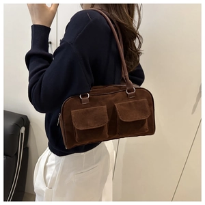Detailed close-up of brown suede shoulder bag with dual front pockets and silver hardware