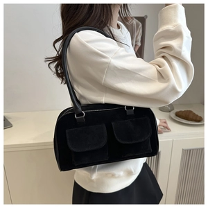 Retro black suede underarm bag with double front flap pockets shown on model shoulder