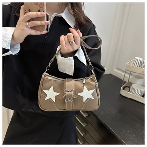 Detail of vintage brown leather underarm bag with white stars and metal star buckle
