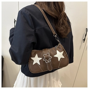 Detail of vintage brown leather underarm bag with white star appliques and contrast stitching