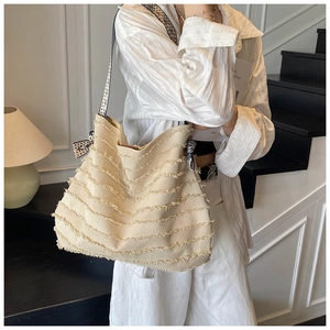 Vue détaillée du cabas en toile beige avec franges et bandoulière à pois chic