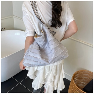 Détail du sac cabas bleu clair avec motif vagues effilochées et sangle géométrique