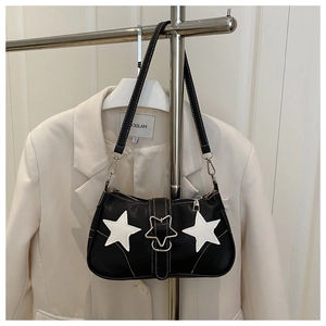 Detailed view of black underarm bag featuring white star patches and star metal buckle