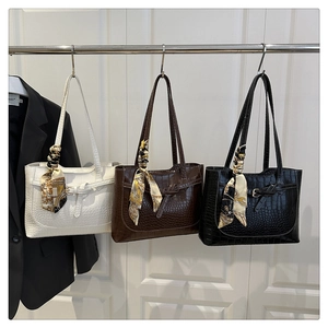 Three crocodile embossed tote bags in white, brown, and black with decorative scarves