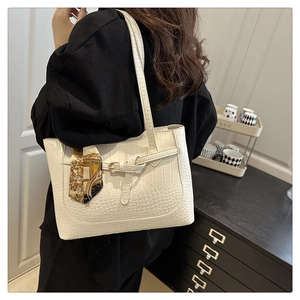 Detail of white crocodile embossed tote bag with elegant floral scarf and buckle