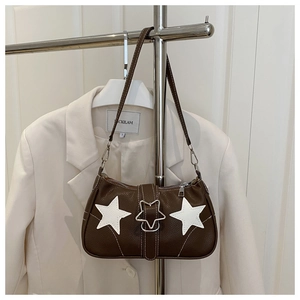 Detail of dark brown leather underarm bag with white star appliques and star buckle