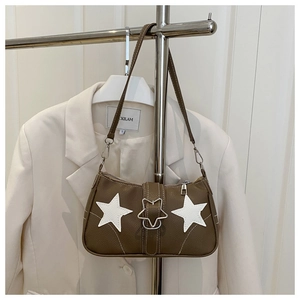 Detail of vintage brown shoulder bag with white star patches and silver buckle