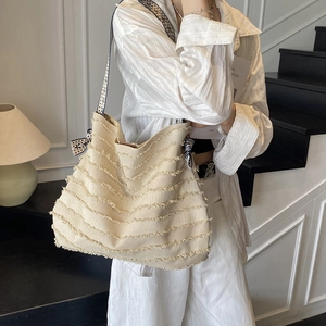 Grand sac cabas en toile beige avec texture à franges et bandoulière à motif géométrique