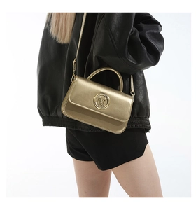 Borsa a tracolla in pelle color oro champagne con logo M indossata da una modella