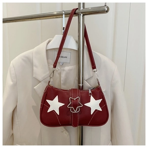 Detail of red leather shoulder bag with white star patches and metal star buckle