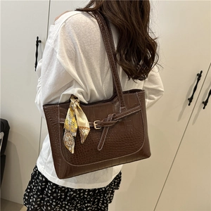 Large dark brown crocodile texture tote bag with yellow silk scarf on casual shoulder