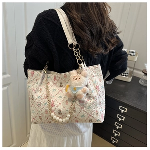Détail du cabas floral avec chaîne en perles, imprimé ours et breloque en peluche