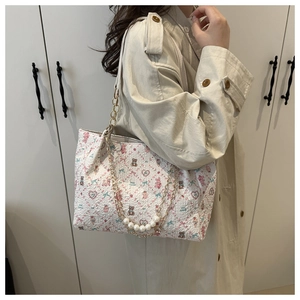 Détail du sac plissé crème avec motifs oursons et chaîne décorative en perles