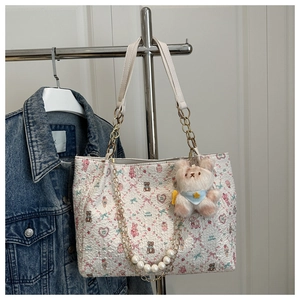 Détail du sac fourre-tout à fleurs avec chaîne en perles et breloque ours en peluche