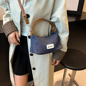 Vintage navy denim hobo bag with brown leather straps and adjustable shoulder strap