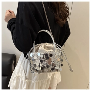 Detailed view of silver sequin bucket bag with drawstring closure and chain strap