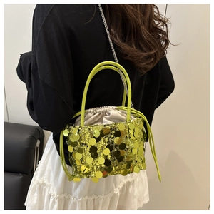 Detail of sequin bucket bag with large metallic green discs and drawstring closure