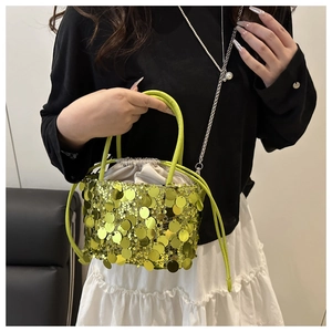 Detail of lime green sequin bucket bag with drawstring closure and silver chain strap