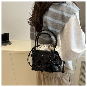 Detail of black sequin bucket bag with drawstring liner and metallic chain strap