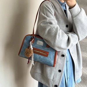 Blue retro tote bag with brown handles and plush bear charm shown on a model