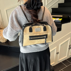 Women's minimalist khaki and black patchwork leather backpack shown on female model back
