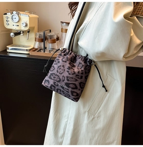 Vue détaillée du sac bourse léopard avec perles métalliques argentées sur le cordon