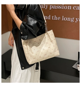 Gros plan du sac cabas beige imprimé ours avec bandoulière en chaîne sur mannequin