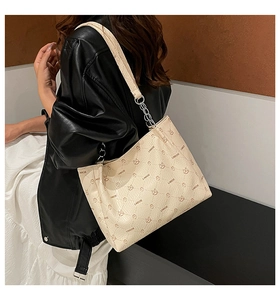 Détail du sac cabas beige avec motif de lapin et attache de bandoulière en chaîne