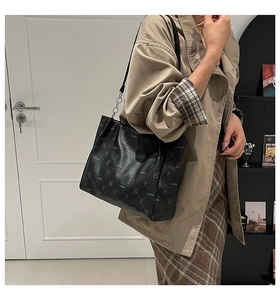 Détail du sac cabas noir LNBOE avec texture autruche et motif d'ours sur la bandoulière