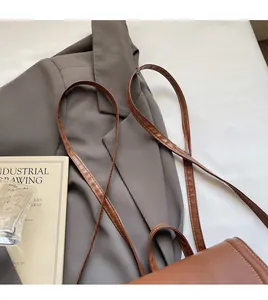 Close-up of brown leather backpack detail with fine stitching and soft shoulder strap