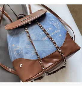 Detail of blue denim backpack with hardware chain decoration and cat print