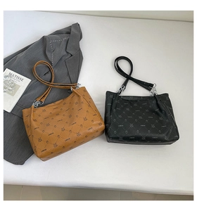 Détail de sacs fourre-tout en cuir marron et noir avec imprimé ours et ferrures