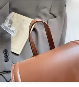 Close-up of the durable reinforced handle on a brown leather vintage backpack for women
