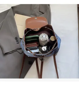 Internal layout of denim and brown leather backpack showing spacious storage capacity
