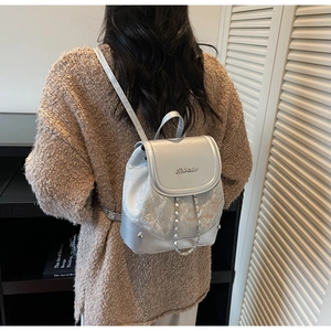Detail view of silver mini backpack featuring feline prints and stylish chain strap