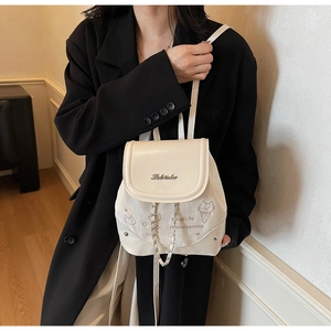 Detail of off-white mini backpack with cute cartoon prints and metal logo on PU leather