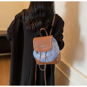 Rear view of model wearing a mini denim and brown PU leather backpack with cat patterns