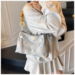 Détail de la poignée en perles de bois et gland sur le sac fourre-tout à fleurs