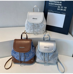 Mini backpacks in white, blue, and silver with cartoon prints and stylish chain details