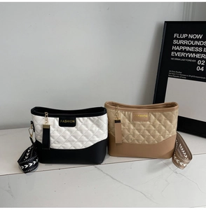 Detail of quilted crossbody bags in black and khaki with fashion embroidered straps