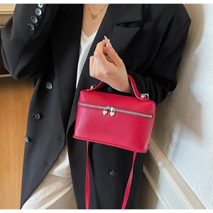 Close-up of red textured leather mini bag with silver heart-shaped zipper detail