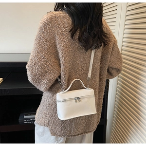 Detail of white litchi pattern mini bag with heart zippers and adjustable strap