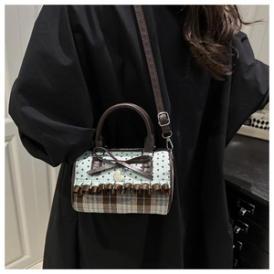 Close-up of sweet bow handbag featuring blue star print and brown plaid textures