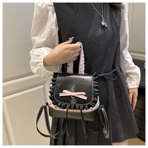 Close-up of mini lace backpack with pink floral texture and heart metal pendant details