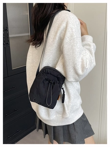 Detailed view of black drawstring crossbody bag featuring Duenin letter decoration