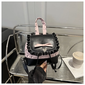 Close-up of mini balletcore backpack featuring black ruffle trim and pink satin bow detail